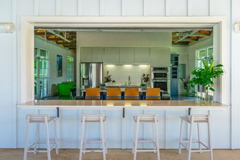 a kitchen with a bar and stools at Anthem Luxury Rental Apartments and Homes in Huntsville, AL